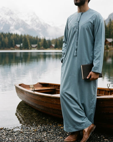 Mirfa Kandura – Men's Light Blue Tassel Emirati Thobe, lakeside with a wooden rowboat – Thobe Wala