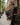 Qassim Thobe – Men's Black Gold Embroidered Saudi Thobe, walking toward camera – Thobe Wala
